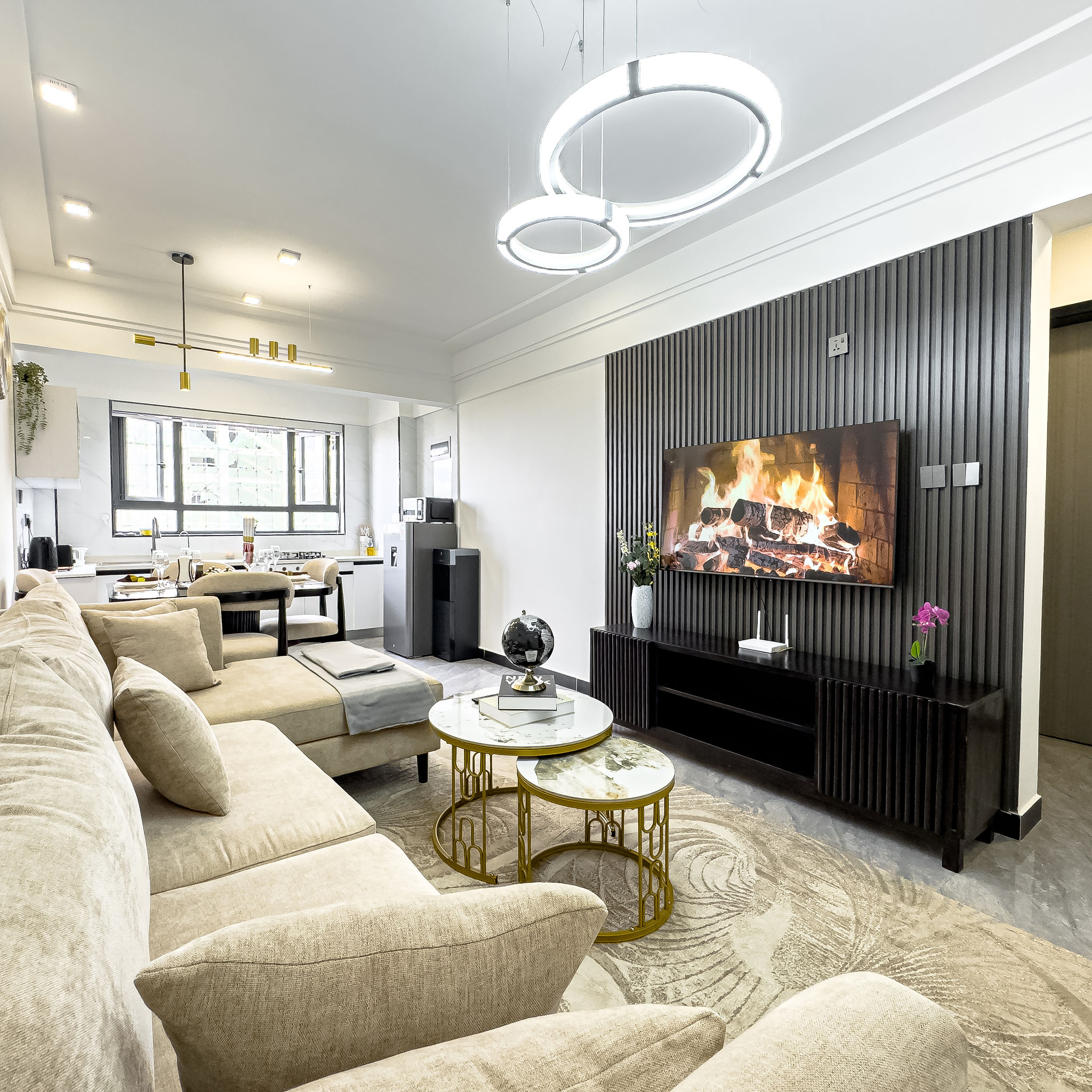 Spacious living room with sofa, TV wall, and dining area